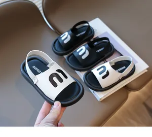 Detail of white kids beach sandal with letter M logo and flexible elastic heel strap