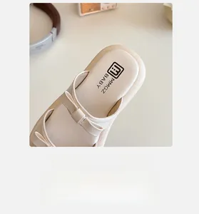 Detail view of cream toddler shoes featuring a soft leather bow and cushioned insole