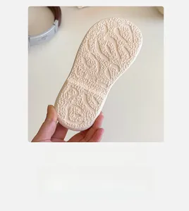 Detailed close-up of a non-slip cream white child shoe sole showing texture and size 28