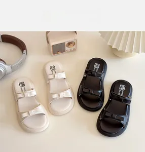 Flat lay of stylish girls' bow sandals in beige and black with vintage accessories
