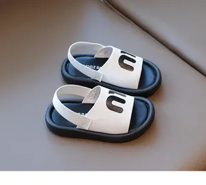 Detailed close-up of girls' leather sandals with black letters and elastic heel straps