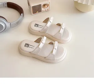 Detail showing cream-colored kids sandals with double bow straps and thick anti-slip soles