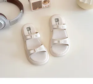 Detailed view of beige kids sandals with double bow straps and comfortable thick soles