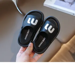 Detailed close-up of a black toddler sandal with white 'm' letter and elastic heel strap