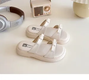 Close-up of off-white children's slide sandals with elegant double bow design
