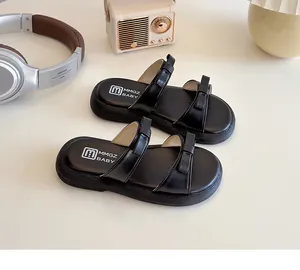 Close-up of kids black double-strap sandals featuring bow accents and soft cushioned footbed