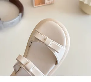Macro detail of cream platform sandals with elegant double bow design and leather texture
