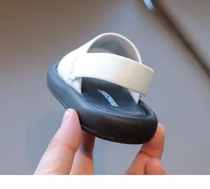 Detail of kids black and white sandals featuring elastic heel strap and non-slip thick sole
