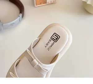 Close-up of off-white toddler sandals with soft bow detail and non-slip sole texture