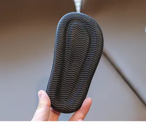 Close-up of children's black sandal sole featuring anti-slip wavy rubber texture