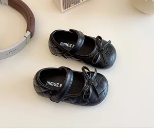 Dettaglio delle scarpe Mary Jane nere trapuntate da bambina con fiocco e cinturino a strappo