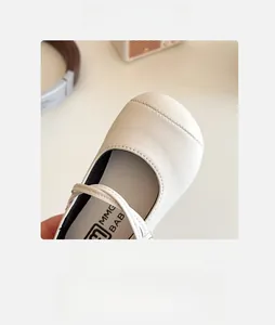 Close-up of wide round toe design and smooth texture on cream Mary Jane shoes