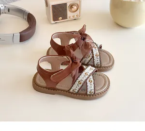 Détails de broderie et nœud en tulle marron sur sandales vintage de princesse pour fille