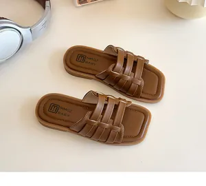 Détail des sandales marron pour filles avec brides tressées et semelle plate antidérapante