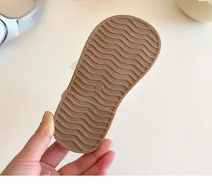 Détail de la semelle antidérapante en caoutchouc marron avec motifs ondulés pour sandales fille