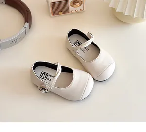 Detail of white girls Mary Jane shoes with pearl flower buckles and soft leather texture