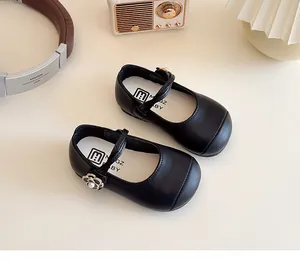 Detailed view of black Mary Jane shoes with camellia pearl buckle and soft soles