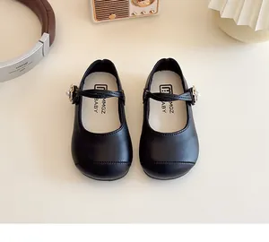 Detail of girls' black Mary Jane shoes featuring pearl flower buckles and cross straps