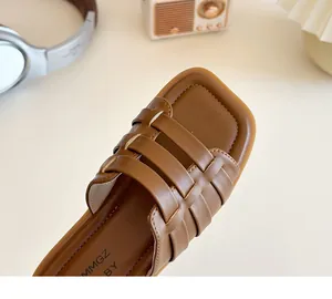 Détail macro des lanières tressées en cuir marron sur sandales à bout carré pour filles