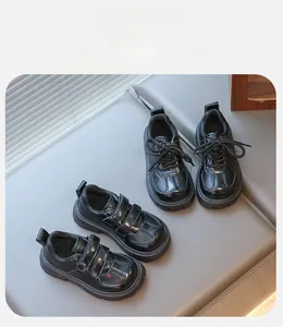 Detailed macro view of black faux leather kids dress shoes with velcro and lace-up closure