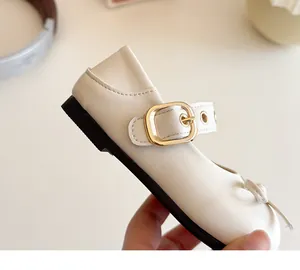 Detailansicht der cremefarbenen Mary Jane Schuhe mit goldener Schnalle und Schleife