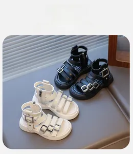 Detail of girls' gladiator sandals with multi-straps and metal buckles in black and white