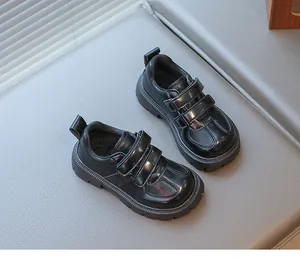 Close-up of kids' black formal shoes with dual Velcro straps and thick rubber soles