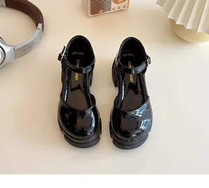Detail von Mädchen Mary Janes aus schwarzem Lackleder mit dicker Gummisohle und Schnallenriemen