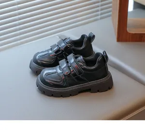 Close-up of black leather kids' dress shoes with double Velcro straps and non-slip rubber soles