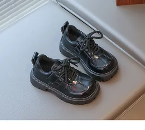 Detail view of round toe kids black leather shoes with thick sole and stitching