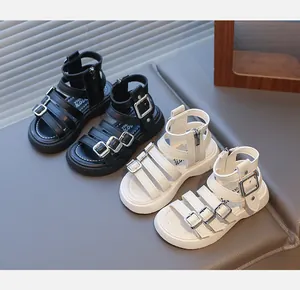 Detail of children's gladiator sandals in black and white with side zipper and buckles