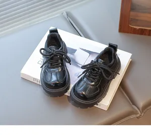 Macro detail of glossy black leather kids shoes with stitching and non-slip thick soles