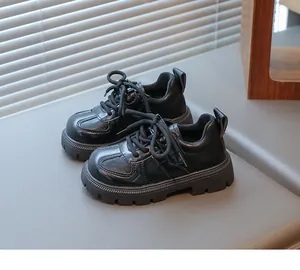 Detail view of children's black patent leather shoes with thick soles and lace-up design
