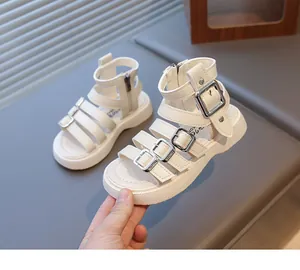 Detail view of white Roman sandals with adjustable metal buckles and rear zipper closure