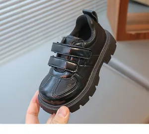 Detail of children black leather shoes featuring durable double hook and loop straps