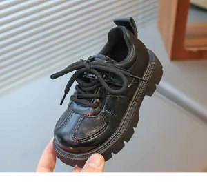 Macro detail of kids black leather dress shoe featuring thick anti-slip rubber sole