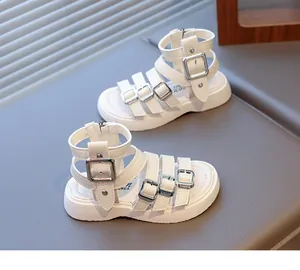 Close-up of white gladiator girls sandals with buckle straps and a rear zipper closure