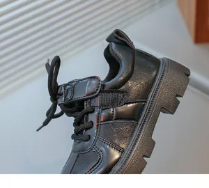 Detail of black synthetic leather children shoes with velcro strap and lug rubber sole