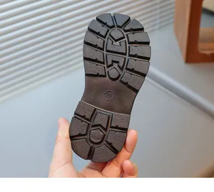 Close-up of brown rubber sole featuring deep non-slip treads and size 26 marking