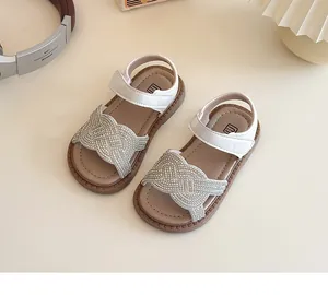 Detalle de sandalias para niña con strass, cierre de velcro y suela de goma flexible
