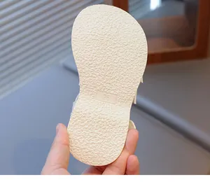 Detailed macro view of the non-slip outsole texture and size 26 mark on girls sandals