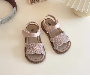 Detalle de sandalias rosas para niñas con tiras de diamantes de imitación y cierre de velcro