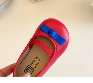 Detail eines roten Mädchen-Prinzessin-Schuhs mit blauer Satinschleife und Gummiband