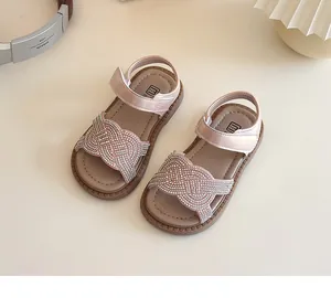 Detalle macro de sandalias rosas con strass para niñas y correa ajustable de velcro