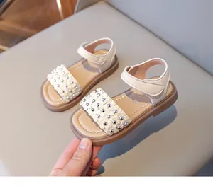Détail de sandales beiges pour filles avec fleurs appliquées et semelles antidérapantes