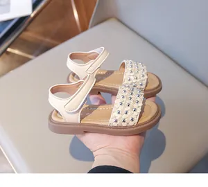 Détail de sandales de princesse beige pour filles avec fermeture velcro et ornements floraux