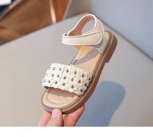 Détail de sandales pour filles avec fleurs 3D et rivets argentés sur la bride