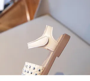 Détails des fleurs et de la fermeture velcro sur les sandales plates pour filles