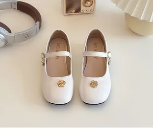 Dettaglio di scarpe Mary Jane bianche in pelle verniciata per bambina con fibbia d'oro
