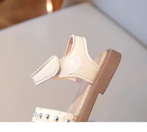 Gros plan de sandales beiges pour filles avec fleurs et sangle velcro à la cheville